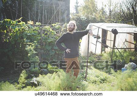 Stock Photo - "Young man in garden, portrait". Fotosearch