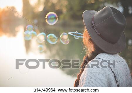 Young woman blowing bubbles View Large Photo Image Picture - Young woman blowing bubbles. Fotosearch
