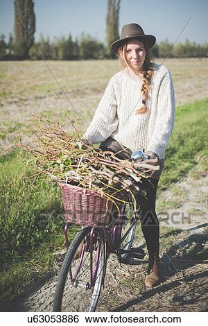 Young woman carrying bunch of sticks on bicycle View Large Photo Image Stock Photograph - Young woman carrying bunch of sticks on bicycle. Fotosearch