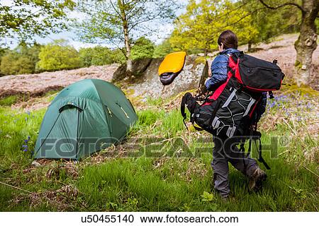 Stock Image - "Young woman carrying camping gear, Pateley Bridge, Nidderdale, Yorkshire Dales". Fotosearch
