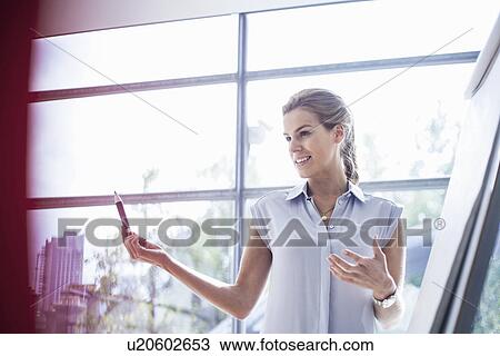 Stock Image - Young woman conducting training presentation. Fotosearch