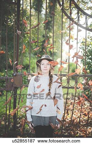 Stock Photo - Young woman in falling autumn leaves. Fotosearch
