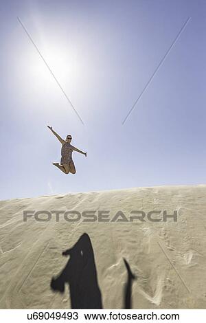 "Young woman jumping mid air, Dune de Pilat, France" View Large Photo Image Stock Image - "Young woman jumping mid air, Dune de Pilat, France". Fotosearch