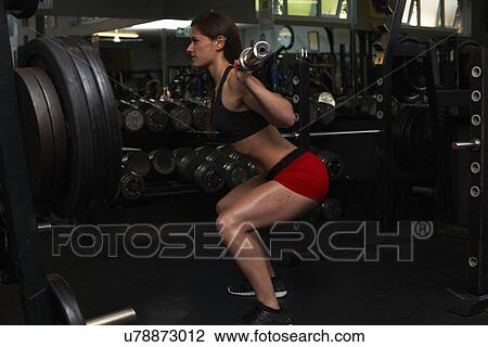 Stock Image - "Young woman, lifting weights". Fotosearch