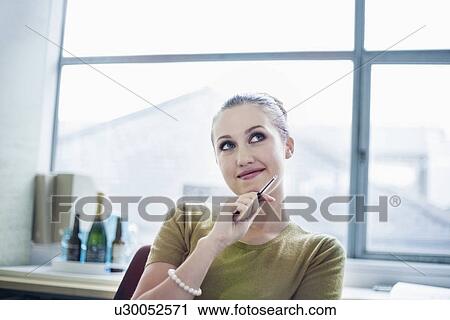 Stock Image - Young woman looking up and smiling. Fotosearch