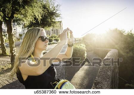 "Young woman photographing with smartphone, Biarritz, France" View Large Photo Image Stock Image - "Young woman photographing with smartphone, Biarritz, France". Fotosearch