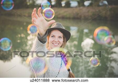 Young woman playing with bubbles View Large Photo Image Stock Photo - Young woman playing with bubbles. Fotosearch
