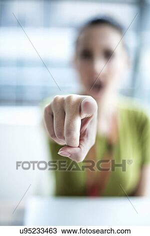 Stock Image - Young woman pointing finger. Fotosearch