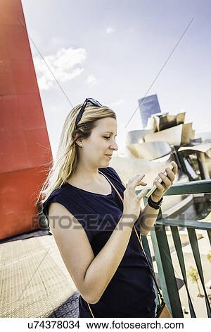 "Young woman reading smartphone texts, Bilbao, Spain" View Large Photo Image Picture - "Young woman reading smartphone texts, Bilbao, Spain". Fotosearch