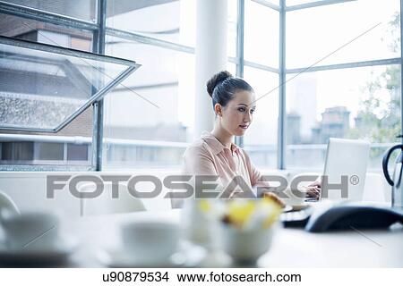 Young woman using laptop at meeting room table View Large Photo Image Picture - Young woman using laptop at meeting room table. Fotosearch