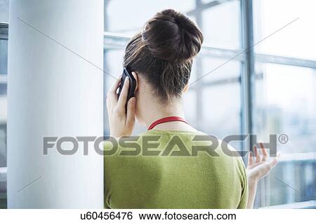 Young woman using smartphone beside pillar View Large Photo Image Stock Photograph - Young woman using smartphone beside pillar. Fotosearch