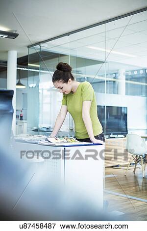 Young women reading magazine in office View Large Photo Image Stock Photo - Young women reading magazine in office. Fotosearch