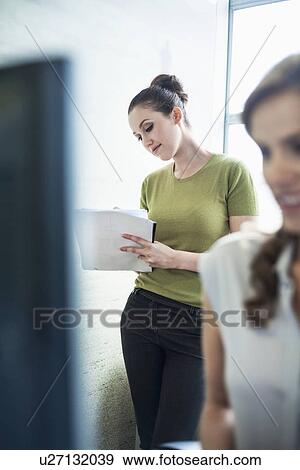 Stock Photo - Young women working in office. Fotosearch