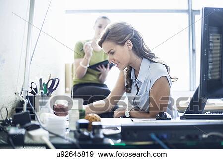 Stock Photo - Young women working in office. Fotosearch