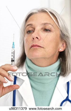 Female doctor holding injection View Large Photo Image Stock Photo - Female doctor holding injection. Fotosearch