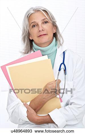Mature female doctor holding files View Large Photo Image Stock Image - Mature female doctor holding files. Fotosearch