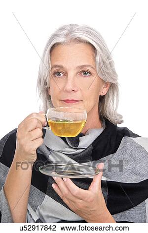 Stock Image - Mature woman drinking herbal tea. Fotosearch