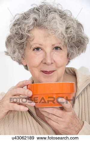 Stock Photo - Woman holding an orange bowl. Fotosearch