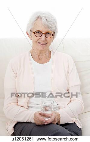 Stock Image - Woman holding glass of water. Fotosearch