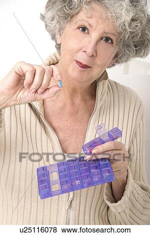 Woman holding pill and pill container View Large Photo Image Stock Photo - Woman holding pill and pill container. Fotosearch
