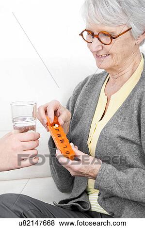 Woman holding pill container View Large Photo Image Stock Photo - Woman holding pill container. Fotosearch