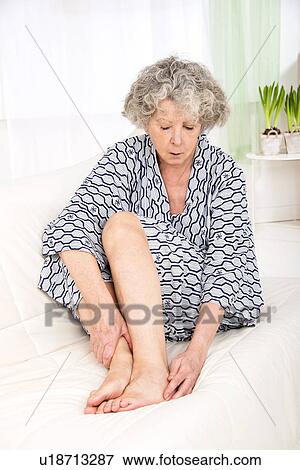 Stock Photo - Woman touching her ankle. Fotosearch