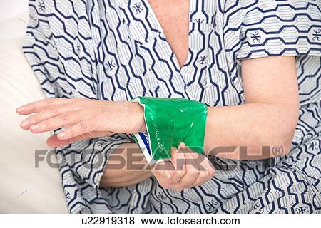 Woman with a cold compress on wrist View Large Photo Image Stock Photo - Woman with a cold compress on wrist. Fotosearch