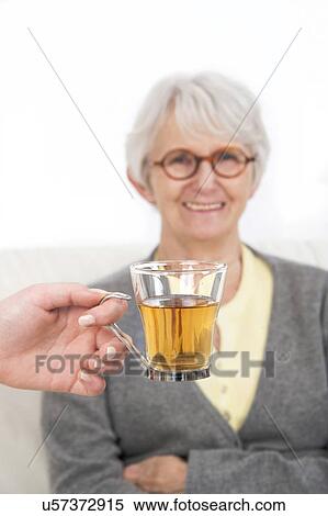 Woman with a hand holding glass of tea View Large Photo Image Stock Photography - Woman with a hand holding glass of tea. Fotosearch