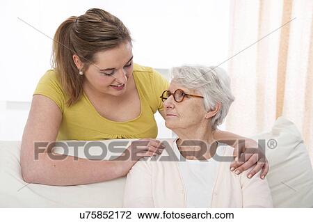 Stock Image - Woman with her hands on shoulders of woma. Fotosearch