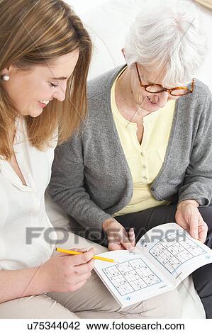 Women doing puzzle View Large Photo Image Stock Image - Women doing puzzle. Fotosearch