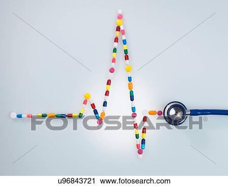 Stock Image - Acoustic stethoscope attached to electrocardiogram of a human heart made up of medicine. Fotosearch