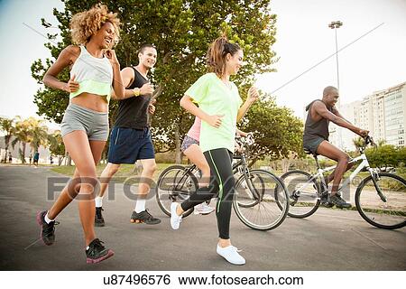 Adult friends doing training cycle and run in park View Large Photo Image Stock Photograph - Adult friends doing training cycle and run in park. Fotosearch