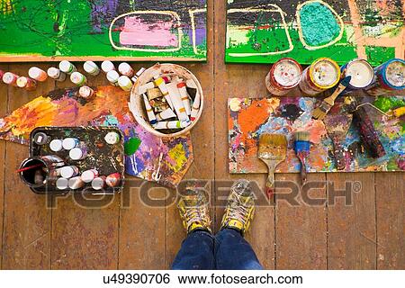 Stock Photograph - Artist selfie of feet paints and abstract painting in studio. Fotosearch
