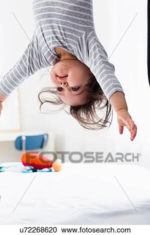 Stock Image - Baby boy hanging upside-down. Fotosearch