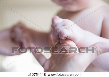 Stock Photo - "Baby boy holding mother's hands, focus on hands". Fotosearch