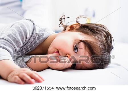 "Baby boy lying down, sucking thumb" View Large Photo Image Picture - "Baby boy lying down, sucking thumb". Fotosearch