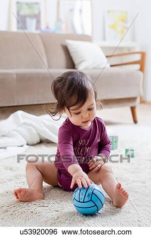 Stock Photograph - Baby boy playing on floor. Fotosearch