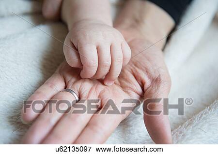 "Baby boy's hand resting on mother's hand, close-up" View Large Photo Image Stock Photo - "Baby boy's hand resting on mother's hand, close-up". Fotosearch
