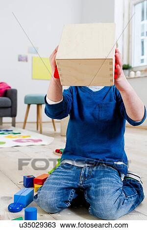 Boy covering face with wooden box View Large Photo Image Stock Image - Boy covering face with wooden box. Fotosearch