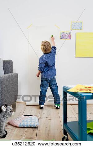 Stock Image - Boy drawing on wall. Fotosearch