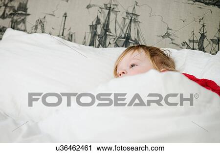 Stock Image - Boy lying in bed. Fotosearch