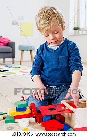 Boy playing with building blocks at home View Large Photo Image Stock Photography - Boy playing with building blocks at home. Fotosearch