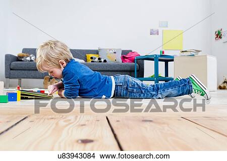 Boy playing with digital tablet on wooden floor View Large Photo Image Picture - Boy playing with digital tablet on wooden floor. Fotosearch