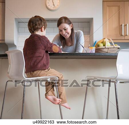 Boy sitting on stool with mother in kitchen and drawing View Large Photo Image Stock Image - Boy sitting on stool with mother in kitchen and drawing. Fotosearch