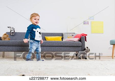Boy standing beside sofa at home View Large Photo Image Stock Photo - Boy standing beside sofa at home. Fotosearch