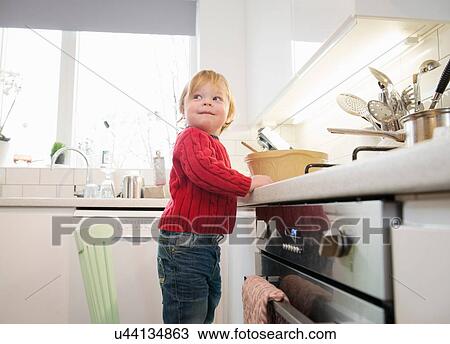 Boy standing on chair in kitchen View Large Photo Image Stock Image - Boy standing on chair in kitchen. Fotosearch