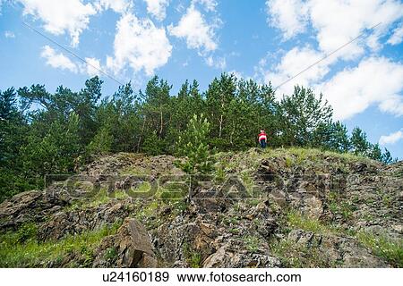 Boy standing on top of rocky cliff View Large Photo Image Stock Photo - Boy standing on top of rocky cliff. Fotosearch