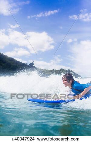 Boy surfer riding the wave View Large Photo Image Picture - Boy surfer riding the wave. Fotosearch