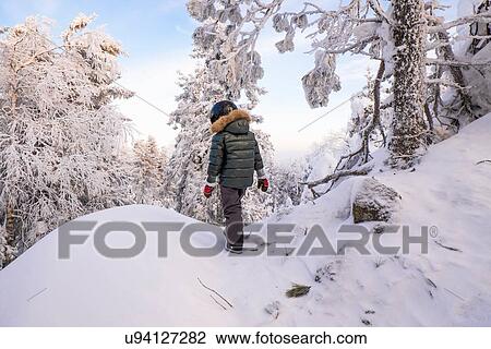 "Boy walking in snow covered mountain forest, Nizhniy Tagil, Sverdlovsk Region, Russia" View Large Photo Image Stock Image - "Boy walking in snow covered mountain forest, Nizhniy Tagil, Sverdlovsk Region, Russia". Fotosearch