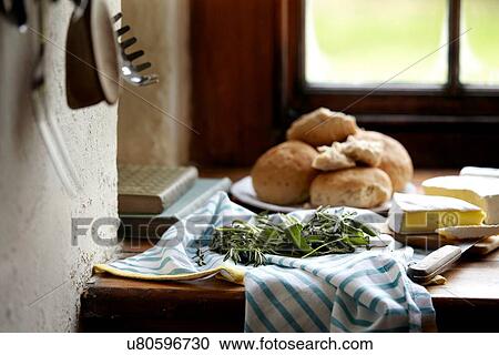 Stock Image - Bread rolls and brie on kitchen counter. Fotosearch